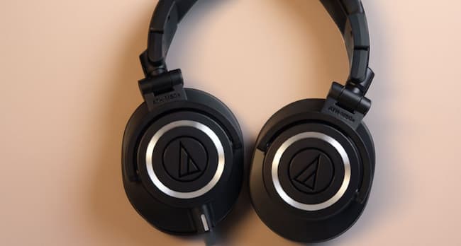 A pair of black Audio-Technica wired headphones on a white surface