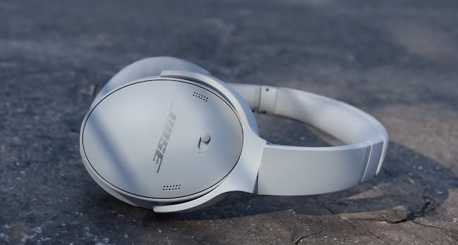 A pair of white Bose headphones on the ground