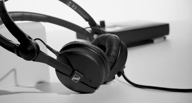 A pair of black wired headphones on a white surface
