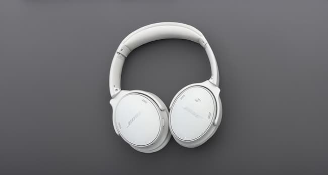 A pair of white Bose headphones on a grey background
